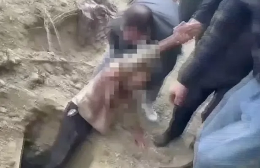 Мужчину вытаскивают из могилы. ФОТО: DAILYMAIL.CO.UK